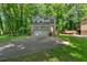View of the home featuring a long driveway, two-car garage and mature trees with a large deck area at 2766 Stonecreek Se Rd, Smyrna, GA 30080