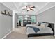 Spacious main bedroom featuring a tray ceiling, ceiling fan, dresser, mirror, and two windows at 2766 Stonecreek Se Rd, Smyrna, GA 30080