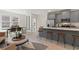 Open-concept kitchen featuring stainless steel appliances, gray cabinetry, and a central island with bar stool seating at 3142 Washburn St, Atlanta, GA 30354