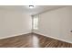 Clean, minimal bedroom with hardwood floors, neutral paint, and bright natural light at 355 Pintail Ct, Suwanee, GA 30024