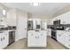 Well-lit kitchen featuring white cabinets, stainless steel appliances and a center island at 355 Pintail Ct, Suwanee, GA 30024