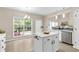 Kitchen featuring an island with stainless steel appliances, ample lighting, and backyard views at 355 Pintail Ct, Suwanee, GA 30024