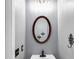 Modern powder room with an oval mirror and a vessel sink with a black faucet at 355 Pintail Ct, Suwanee, GA 30024