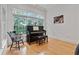 Bright sun room with hardwood floors and piano by large window at 1003 Pearl Ne Pt, Sandy Springs, GA 30328