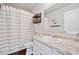 Bright bathroom featuring granite countertops, striped shower curtain, and wood-look flooring at 117 Point View Dr, Canton, GA 30114