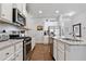 Well-lit kitchen featuring granite countertops, white cabinets, and stainless steel appliances at 117 Point View Dr, Canton, GA 30114