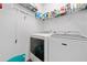 Neat laundry room with white washer and dryer and shelving for storage at 117 Point View Dr, Canton, GA 30114