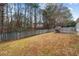Exterior shot of grassy backyard featuring a concrete patio with rustic wooden benches and a wooden fence at 2457 Swan Lake Dr, Grayson, GA 30017