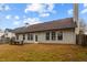 Exterior shot of backyard featuring a concrete patio with rustic wooden benches, lush green grass, and a wooden fence at 2457 Swan Lake Dr, Grayson, GA 30017