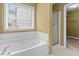Bathroom featuring a soaking tub, window, and shower at 2457 Swan Lake Dr, Grayson, GA 30017