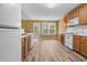 Open kitchen layout with wooden cabinets, white appliances and hardwood floors at 2457 Swan Lake Dr, Grayson, GA 30017