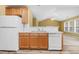 Kitchen with wooden cabinets and white appliances overlooking the living space at 2457 Swan Lake Dr, Grayson, GA 30017
