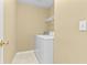 Neutral laundry room with white washer and dryer at 2457 Swan Lake Dr, Grayson, GA 30017