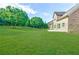 Large grassy backyard next to the home with mature trees at 468 Scott Farm Dr, Powder Springs, GA 30127