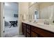 Modern bathroom featuring dual sinks, a large mirror, and a view into another room at 468 Scott Farm Dr, Powder Springs, GA 30127