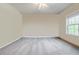 Spacious bedroom with neutral walls, plush carpet, and a large window with natural light at 468 Scott Farm Dr, Powder Springs, GA 30127