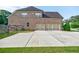 Rear exterior of a brick home with a long driveway and a three-car garage at 468 Scott Farm Dr, Powder Springs, GA 30127