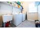 Functional laundry room with washer, dryer, and sink offering convenience and storage space at 468 Scott Farm Dr, Powder Springs, GA 30127