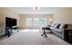 Spacious living room with a large sectional sofa, contemporary TV, and ample natural light at 468 Scott Farm Dr, Powder Springs, GA 30127