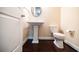 Elegant powder room features pedestal sink, elongated toilet, and rich dark wood floors at 468 Scott Farm Dr, Powder Springs, GA 30127