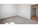 A clean, carpeted bedroom with a white door and trim and a view into the hallway at 470 Village Ln, Fairburn, GA 30213