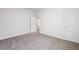 Clean, carpeted bedroom with a white door and trim and a view into the hallway at 470 Village Ln, Fairburn, GA 30213