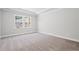 An empty bedroom featuring carpet and gray walls, with a double window and white trim and baseboards at 470 Village Ln, Fairburn, GA 30213