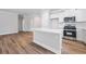 Modern kitchen with a central island, stainless steel appliances, and hardwood floors at 470 Village Ln, Fairburn, GA 30213