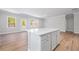 Modern kitchen boasts an island, modern appliances, white cabinets and beautiful wood flooring at 470 Village Ln, Fairburn, GA 30213