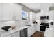 Modern kitchen with white cabinets, stainless steel appliances, quartz countertops, and a herringbone backsplash at 470 Village Ln, Fairburn, GA 30213