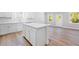 New kitchen boasts an island, modern appliances, white cabinets and beautiful wood flooring at 470 Village Ln, Fairburn, GA 30213