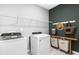 Well-equipped laundry room boasts modern appliances, storage shelving, and stylish organizational accessories at 470 Village Ln, Fairburn, GA 30213