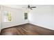 This bright bedroom features two windows, a ceiling fan, and beautiful dark hardwood floors at 1198 Larson Sw Ln, Marietta, GA 30064