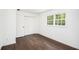A bright bedroom featuring hardwood floors, double door closet, and a window with a view at 1198 Larson Sw Ln, Marietta, GA 30064