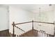The upstairs hallway features wood railings, hardwood floors, and a charming window at 1198 Larson Sw Ln, Marietta, GA 30064