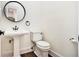 Stylish powder room featuring a pedestal sink, dark fixtures, and hardwood flooring at 1198 Larson Sw Ln, Marietta, GA 30064