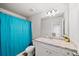 Functional bathroom featuring a vanity with a sink and a shower with a blue curtain at 20 Tarpley Way, Covington, GA 30016