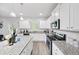 Modern kitchen boasts white cabinets, granite countertops, and stainless steel appliances at 20 Tarpley Way, Covington, GA 30016