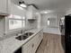 Well-lit kitchen with new stainless steel sink and granite countertops at 2550 Stoney Brook Ne Ln, Marietta, GA 30062