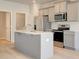 Modern kitchen features stainless steel appliances, light wood flooring, and a spacious center island at 305 Heavenly Hollow Pl, Mcdonough, GA 30253