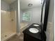 Bathroom with dual sinks, black granite countertop, tub, and a separate walk-in shower at 4790 Brandon Acres Ln, Buford, GA 30519