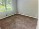 Cozy bedroom featuring plush carpeting, neutral walls, and a large window for natural light at 4790 Brandon Acres Ln, Buford, GA 30519