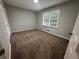 Cozy bedroom featuring neutral walls, plush carpet, and a window providing natural light at 4790 Brandon Acres Ln, Buford, GA 30519