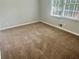 Inviting bedroom featuring a cozy carpet, soft neutral walls and a window at 4790 Brandon Acres Ln, Buford, GA 30519