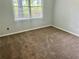 This bedroom features neutral paint and carpeting with a window providing natural light at 4790 Brandon Acres Ln, Buford, GA 30519