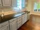 Well lit kitchen with gray cabinets, granite countertops and stainless steel appliances at 4790 Brandon Acres Ln, Buford, GA 30519