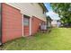 Side view of the property shows a well-maintained lawn with ample space and mature trees at 5791 Cobbrook Dr, Ellenwood, GA 30294