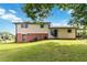Spacious backyard featuring a lush lawn, mature trees, and a patio area at 5791 Cobbrook Dr, Ellenwood, GA 30294