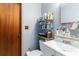 Small bathroom with a white sink, a wooden door, and an open storage shelf at 5791 Cobbrook Dr, Ellenwood, GA 30294