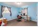 Bright bedroom with blue walls, large windows, and an office area at 5791 Cobbrook Dr, Ellenwood, GA 30294